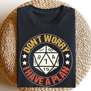 May include: Black t-shirt with a white and yellow graphic of a 20-sided die with the text "Don't Worry I Have A Plan".
