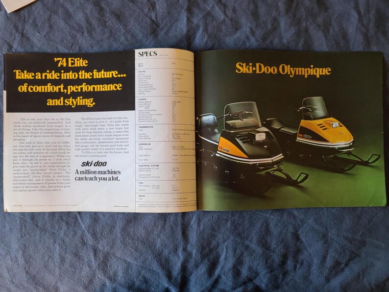 May include: A vintage magazine spread showcasing two Ski-Doo snowmobiles. The left page features yellow text: "'74 Elite Take a ride into the future... of comfort, performance and styling." The right page displays "Ski-Doo Olympique" in yellow.