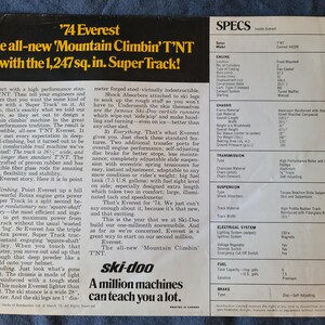 May include: A vintage advertisement for the '74 Everest Ski-Doo snowmobile, with the text 'The all-new Mountain Climbin' T'NT with the 8,045 sq. cm. Super Track!' The ad includes specifications and details about the snowmobile's features.