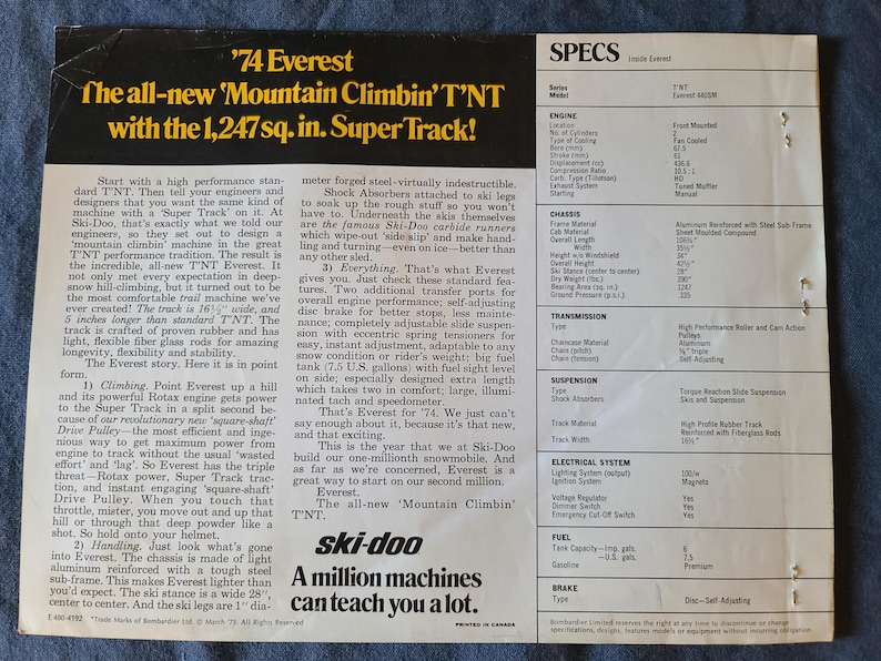 May include: A vintage advertisement for the '74 Everest Ski-Doo snowmobile, with the text 'The all-new Mountain Climbin' T'NT with the 8,045 sq. cm. Super Track!' The ad includes specifications and details about the snowmobile's features.
