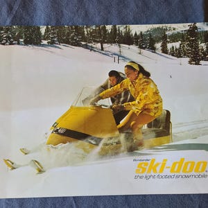 May include: A white ceramic mug with a black handle and the text "But First, Coffee" in a bold, black font. The mug is set against a blurred background, suggesting a cozy setting.