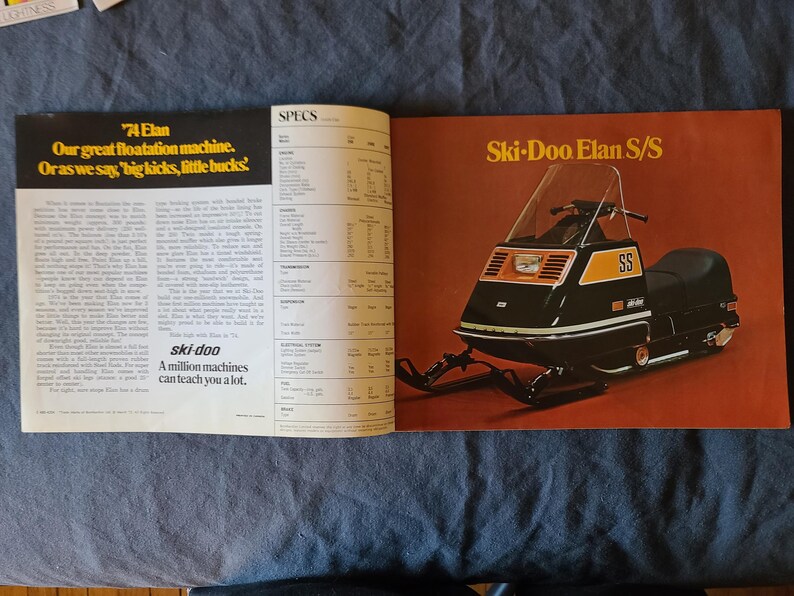 May include: A magazine spread showcasing a vintage Ski-Doo Elan S/S snowmobile. The snowmobile is black with orange detailing and the letters "SS". The page includes text about the snowmobile and the "ski-doo" brand.