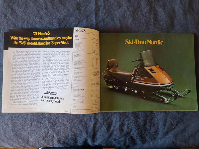 May include: A vintage magazine spread showcasing a Ski-Doo snowmobile advertisement. The right page features a brown and black snowmobile with the text "Ski-Doo Nordic" on a green background. The left page has text that reads "'74 Elan S/S" and "A million machines can teach you a lot."