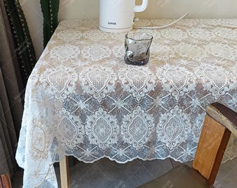 Mantel de encaje bordado: elegante decoración floral para el comedor.