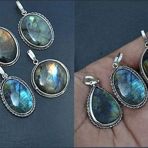 May include: A collection of nine silver pendants with iridescent labradorite gemstones. The pendants are oval, teardrop, and round shapes.
