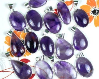 May include: A collection of 15 amethyst gemstone pendants with silver settings. The pendants are in various shapes, including oval and teardrop. The amethyst stones are a deep purple color.