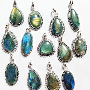 May include: A collection of labradorite gemstone pendants in various shapes, including teardrop and oval. Each pendant features a silver-colored bail and a decorative silver border. The stones display iridescent blue, green, and gold hues.