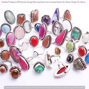 May include: A collection of silver rings with various colorful gemstone inlays. The rings feature a variety of shapes and sizes, including oval, round, teardrop, and rectangular. The gemstones are set in silver bezels and have a polished finish.