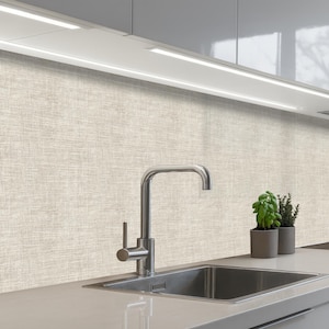 Può includere: Un lavello da cucina moderno con un rubinetto in acciaio inossidabile e un paraschizzi strutturato beige chiaro. Due piccole piante in vaso sono sul piano di lavoro. Sopra, c'è un apparecchio di illuminazione a incasso.