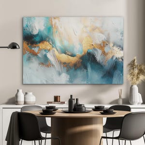 Könnte beinhalten: Abstrakte Leinwandkunst mit Türkis-, Weiß- und Goldtönen. Die strukturierten Pinselstriche erzeugen eine dynamische und moderne Ästhetik. Das Gemälde hängt über einem Esstisch mit schwarzen Stühlen und Geschirr.