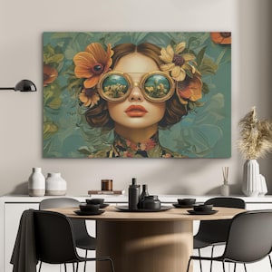 Op de afbeelding: Een canvas print met een vrouw met een bloemen zonnebril en bloemen in haar haar. Het kunstwerk heeft een vintage esthetiek met een turquoise achtergrond en oranje en gele bloemen. De lippen van de vrouw zijn rood en ze draagt een top met bloemenpatroon.