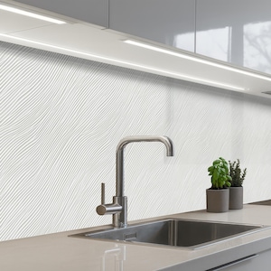Könnte beinhalten: Ein Set aus drei Keramikbechern mit gesprenkelter, matter Oberfläche. Die Becher sind in den Farbtönen Creme, Hellgrau und Dunkelgrau gehalten. Jeder Becher hat ein schlichtes, minimalistisches Design und einen abgerundeten Henkel.