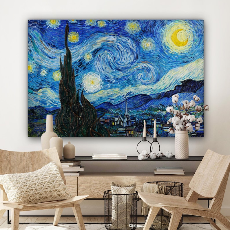 May include: A framed canvas print of Van Gogh's "Starry Night" painting. The artwork features a swirling blue night sky with yellow stars and a crescent moon. A dark, tall cypress tree is in the foreground, with a village below.