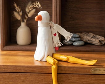 Figurine de canard assis en bois faite main avec écharpe coeur - Statue de canard à longues pattes sculptée à la main - Décoration d'intérieur unique, cadeau de pendaison de crémaillère