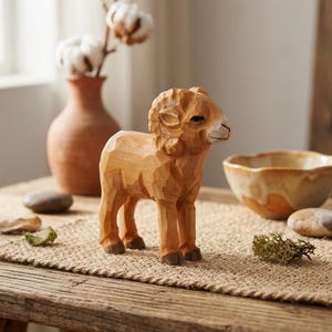 May include: A carved wooden ram figurine, light brown in colour with darker brown hooves. The ram is positioned on a woven mat. A terracotta vase with cotton stems and a decorative bowl are visible in the background. The ram is a decorative item.