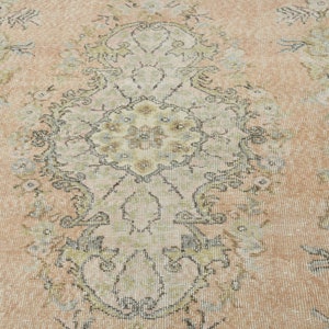 May include: A vintage rug with a faded floral pattern in shades of beige, brown, and blue. The rug has a distressed look and a worn texture.