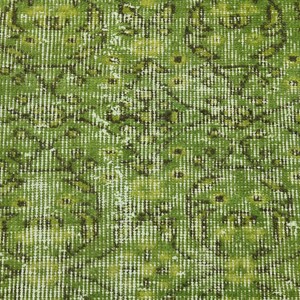 May include: A green rug with a faded floral pattern. The rug has a distressed look and is made of a soft, woven material.