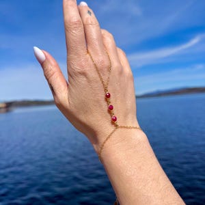 Cadena de mano de oro con 3 rubíes