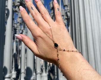 Cadena de mano de oro y turmalina envuelta en ágata negra