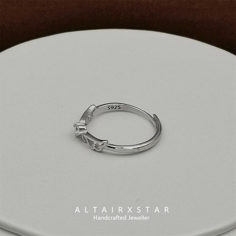 May include: A silver ring with a leaf design and a small square gemstone. The ring is marked with "S925" and the brand name "ALTAIRXSTAR Handcrafted Jeweller" is visible at the bottom.