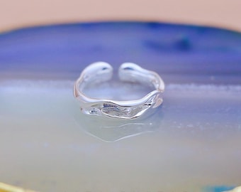 May include: A silver adjustable ring with a textured, organic design. The ring has an open design and is made of a shiny metal. The image also includes the text "ALTAIRXSTAR Handcrafted Jewellery".