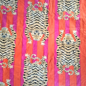 Peut inclure: Un tissu avec un motif répété de rayures orange et roses avec un motif de tigre dans chaque rayure. Les tigres sont tournés vers l'avant, les pattes tendues.