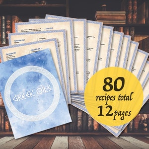May include: A blue and white watercolor design with the text "Greek Oils" in a white circle. The design is on a stack of 12 pages with 80 recipes total. The pages are on a wooden surface in front of a bookshelf.