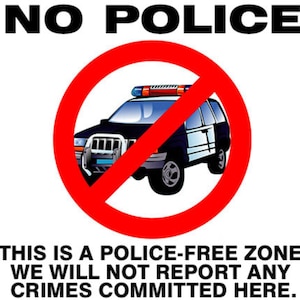 May include: A white sign with the words "NO POLICE" at the top. A red circle with a line through it contains a police car. Below, text reads: "THIS IS A POLICE-FREE ZONE. WE WILL NOT REPORT ANY CRIMES COMMITTED HERE."