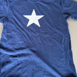 May include: A navy blue t-shirt with a large white star printed on the front.