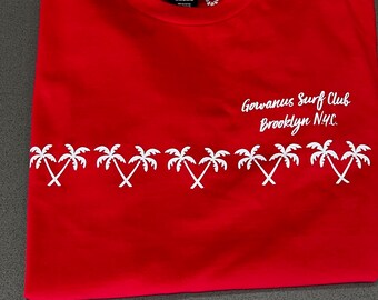 Puede incluir: Camiseta roja con un diseño de palmera blanca y el texto "Gowanus Surf Club Brooklyn NYC."