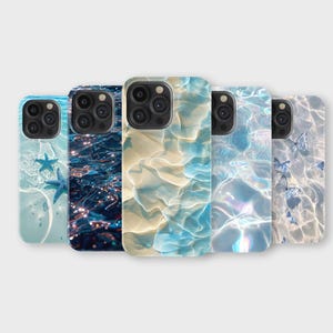 Puede incluir: Una colección de cinco fundas para teléfono con diseños de temática oceánica. Las fundas presentan imágenes de agua, estrellas de mar y patrones acuáticos en tonos azules, blancos y beige. Las fundas están dispuestas en fila, mostrando sus diseños únicos.