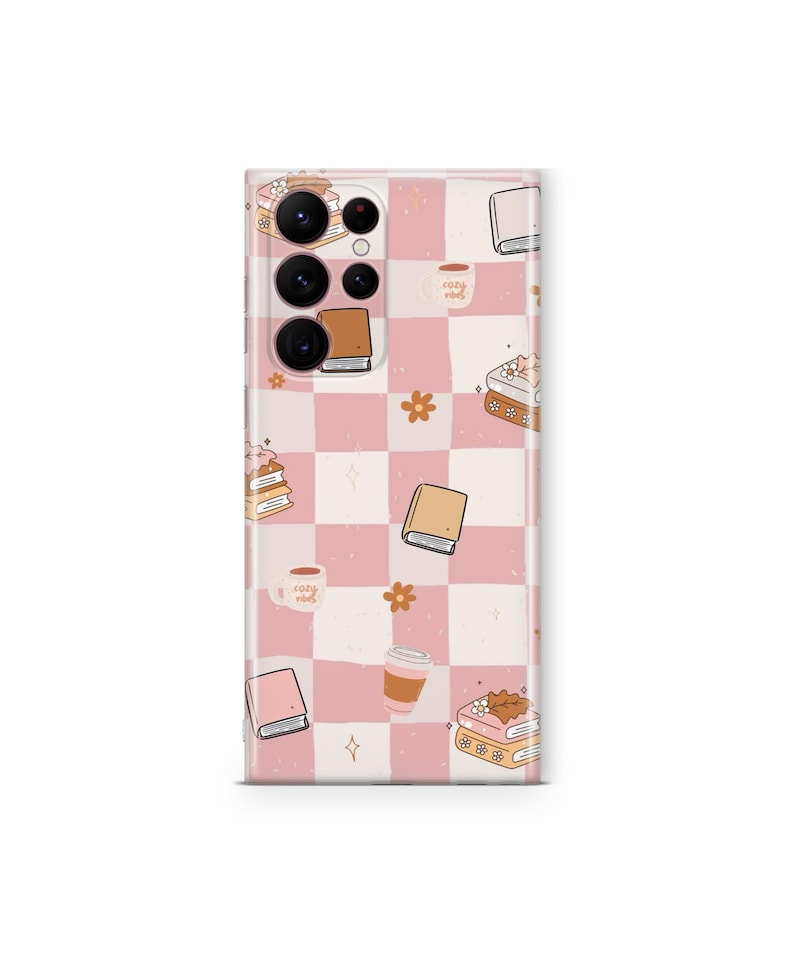 May include: A phone case with a pink and white checkered pattern. The case is decorated with illustrations of books, coffee cups, flowers, and the text "cozy vibes". The case is designed to fit a smartphone.