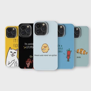 Op de afbeelding: Zes verschillende telefoonhoesjes met verschillende ontwerpen. De hoesjes zijn allemaal zwart en hebben een witte achtergrond. De ontwerpen omvatten een kat met een middelvinger, een leeuw, een geel kuiken, een rode peper, een vis en een kat met een middelvinger. De tekst op de hoesjes luidt "I'm F***ing Stupid", "I'm a Little Chili", "Peace was never an option", en "Selfish".