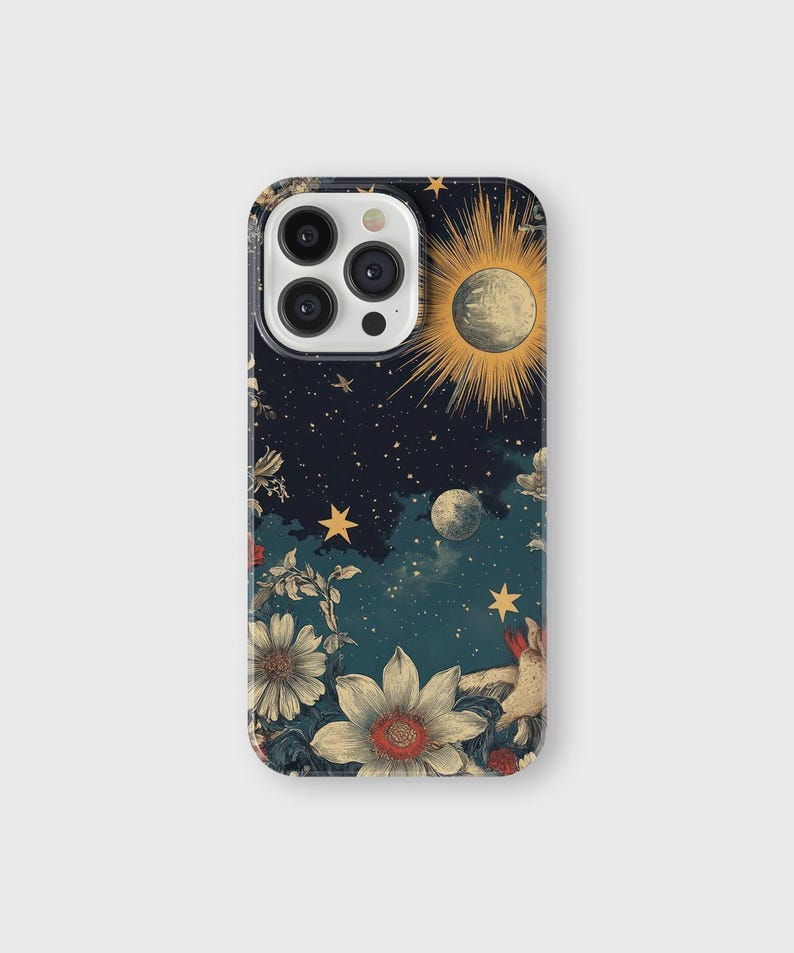 May include: A phone case with a dark blue background featuring a celestial design with stars, moons, and a sun. The design also includes floral elements in shades of red, yellow, and white.