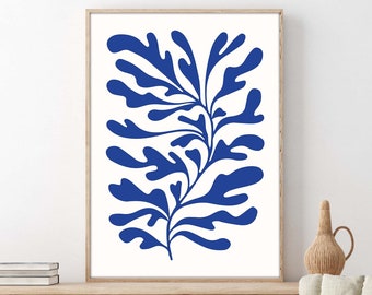 May include: A blue abstract floral print in a wooden frame hanging on a white wall above a wooden dresser with a woven basket and a chair with a straw hat on it.