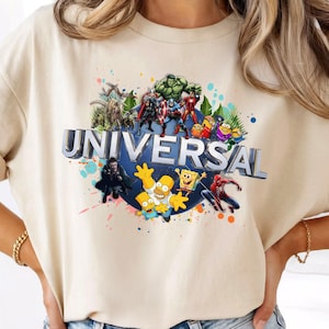 Może przedstawiać: Beżowy t-shirt z krótkim rękawem z nadrukiem słowa UNIVERSAL srebrnymi literami 3D. Wzór zawiera różne postacie z animacji i superbohaterów, takich jak Hulk, Spider-Man, Homer Simpson oraz SpongeBob Kanciastoporty.