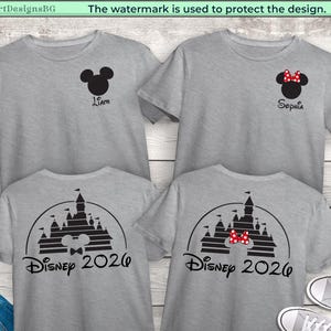 Puede incluir: Cuatro camisetas grises con dise&ntilde;os de Disney. Dos camisetas presentan una cabeza de Mickey Mouse con un nombre, y las otras dos tienen un dise&ntilde;o de castillo con "Disney 2026". Las camisetas se muestran sobre un fondo de vetas de madera clara.