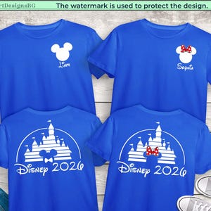 Puede incluir: Cuatro camisetas azules con gr&aacute;ficos blancos. Dos camisetas presentan una cabeza de Mickey Mouse con un nombre, y las otras dos tienen un dise&ntilde;o de castillo con "Disney 2026". Una camiseta tiene un lazo de Minnie Mouse.