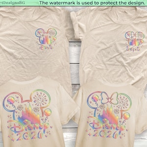May include: Four beige t-shirts with colorful Disney-themed designs. Two shirts feature a Mickey Mouse head with a castle and the name "Sophia". The other two shirts display "Disney 2020" with a castle and Mickey Mouse ears in rainbow colors.