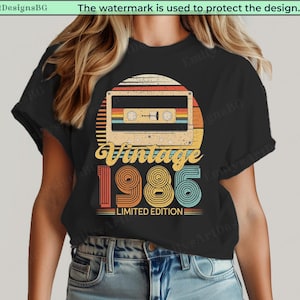 Op de afbeelding: Zwart t-shirt met een retro cassettebandje ontwerp en de tekst "Vintage 1986 Limited Edition". Het ontwerp bevat een zonsondergang-achtige achtergrond en het jaartal 1986 in een kleurrijk vintage lettertype.