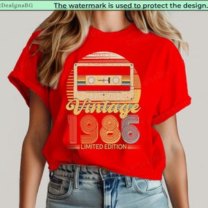 May include: Red t-shirt featuring a retro cassette tape design with the text "Vintage 1986 Limited Edition." The design includes a sunburst background and colorful stripes. The shirt is a classic crew neck.