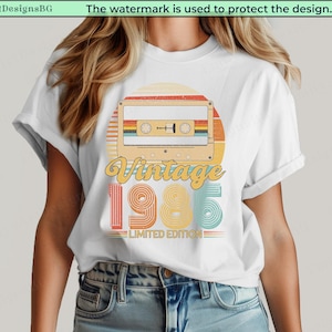 May include: White t-shirt featuring a retro design with a cassette tape illustration. The design includes the words "Vintage 1985 Limited Edition" in a colorful, nostalgic style. The shirt is a classic crew neck.
