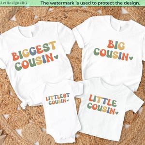 May include: Four white t-shirts and a babygrow with the phrases "Biggest Cousin", "Big Cousin", "Littlest Cousin", and "Little Cousin" in colourful text. They are displayed on a circular woven mat.
