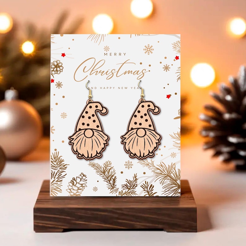 May include: Wooden gnome earrings with black polka dots on the hat and a long, flowing beard. The earrings are displayed on a card that says "Merry Christmas" and "Happy New Year". The earrings are on a wooden stand.