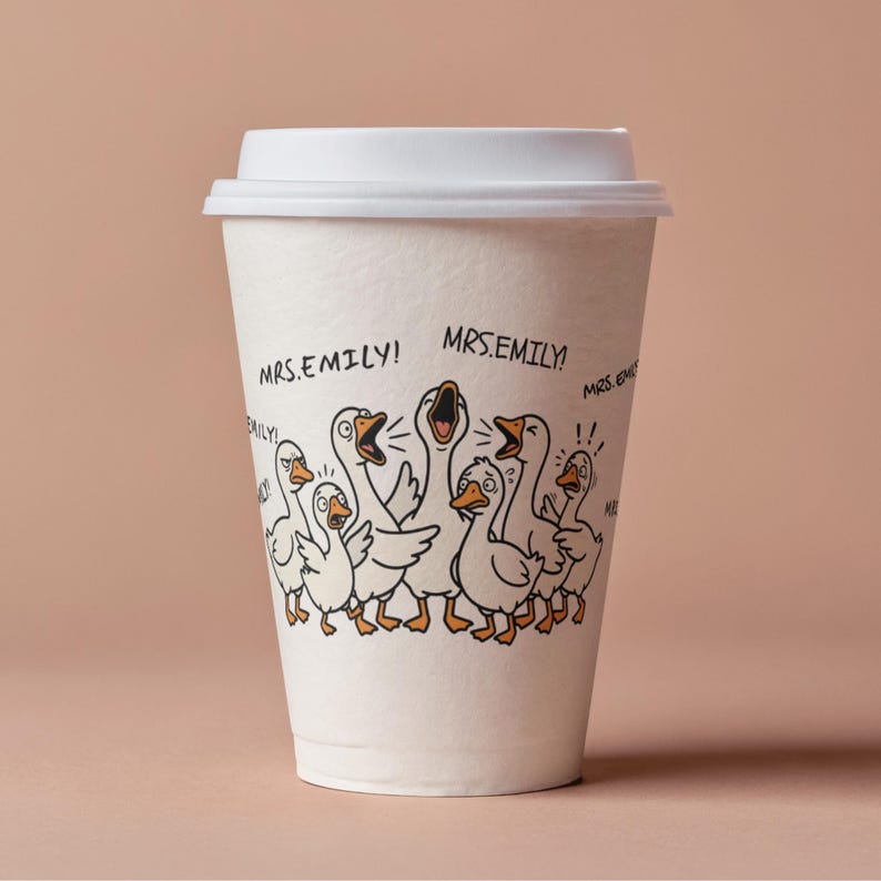 May include: A white paper coffee cup with a white lid. The cup features a cartoon illustration of a flock of geese with open beaks and the text "MRS.EMILY!". The background is a solid light brown.