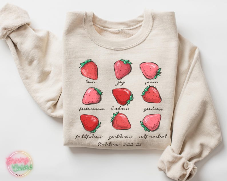 Puede incluir: Una sudadera beige con un gr&aacute;fico de fresas y el texto "love, joy, peace, forbearance, kindness, goodness, faithfulness, gentleness, self-control, Galatians 5:22-23".
