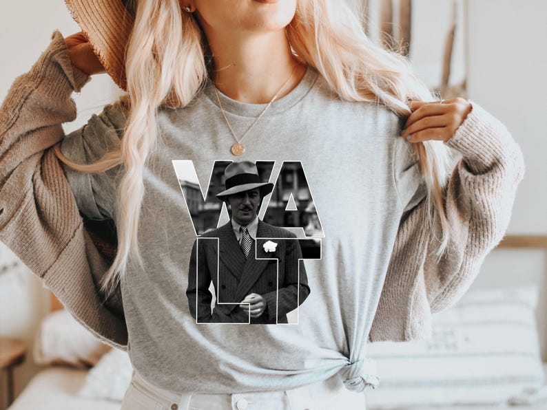 Puede incluir: Camiseta gris de manga larga con una imagen en blanco y negro de un hombre con traje y sombrero. La palabra "WALT" est&aacute; impresa en letras blancas sobre la imagen. La camiseta es de material suave.