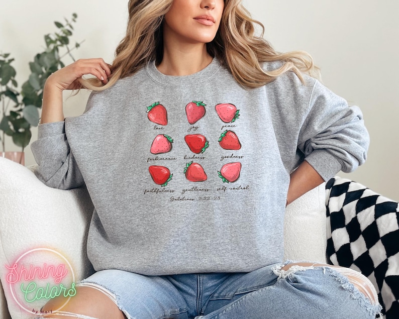 Puede incluir: Sudadera gris con un gr&aacute;fico de fresas y el texto "love, joy, peace, patience, kindness, goodness, faithfulness, gentleness, self-control, Galatians 5:22-23".