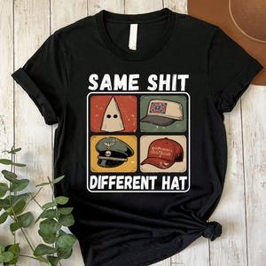 May include: Black t-shirt with the text "SAME SHIT DIFFERENT HAT" above four images of hats. The hats include a white hood, a Confederate flag hat, a military hat, and a "Make America Great Again" hat.