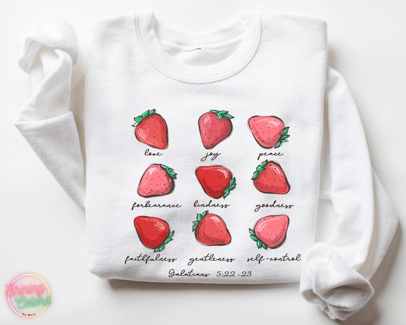 Puede incluir: Sudadera blanca con un gr&aacute;fico de fresas y el texto "love, joy, peace, forbearance, kindness, goodness, faithfulness, gentleness, self-control, Galatians 5:22-23".